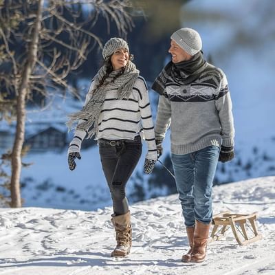 Couple getting ready for tobogganing near Falkensteiner Hotels