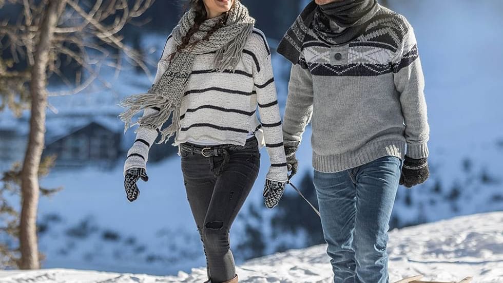 Couple walking on snowy landscape near Falkensteiner Hotel Antholz