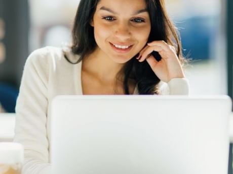 A lady looking at laptop while smiling at Fiesta Americana