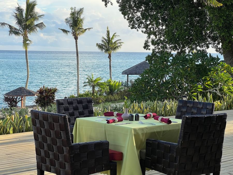 Four chairs around a table with ocean view at Warwick Le Lagon - Vanuatu.