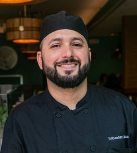 Chef Sebastian smiling in a Chef's Uniform