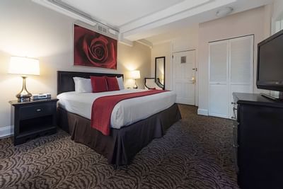 King bed in a room with a large rose painting at Artmore Hotel