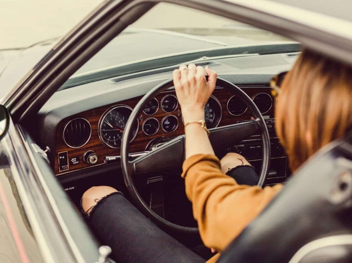 Closeup of a lady holding a steering wheel at Paradox Resort