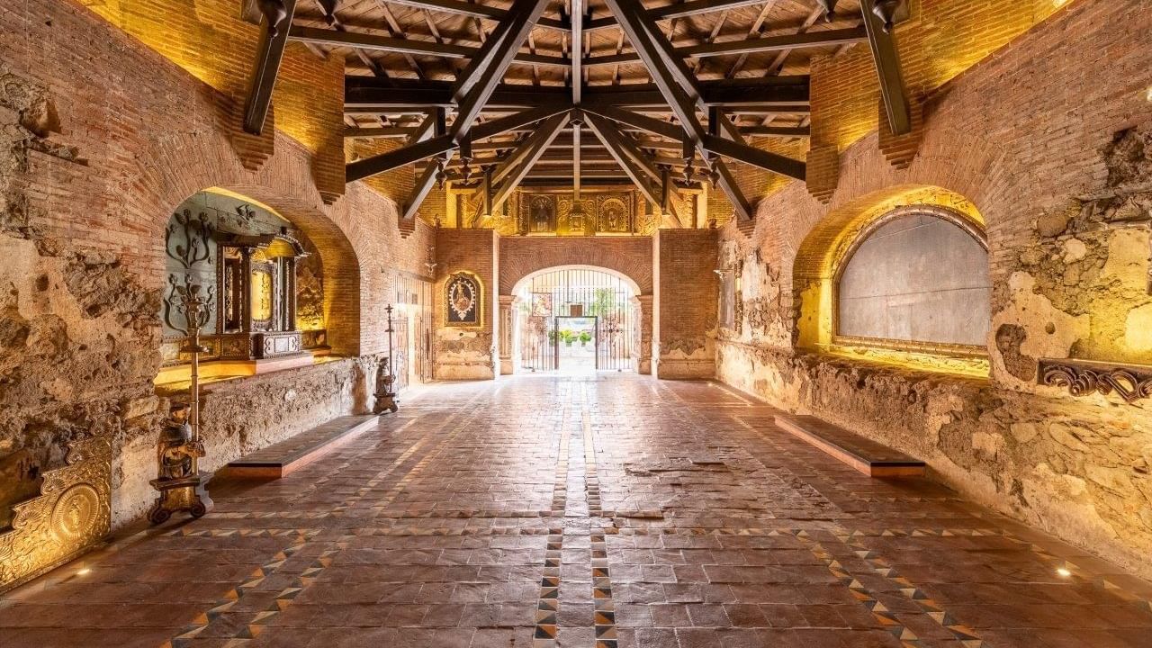 Amplio pasillo de ladrillo restaurado con techos altos en la Capilla del Santo Hermano Pedro en Casa Santo Domingo