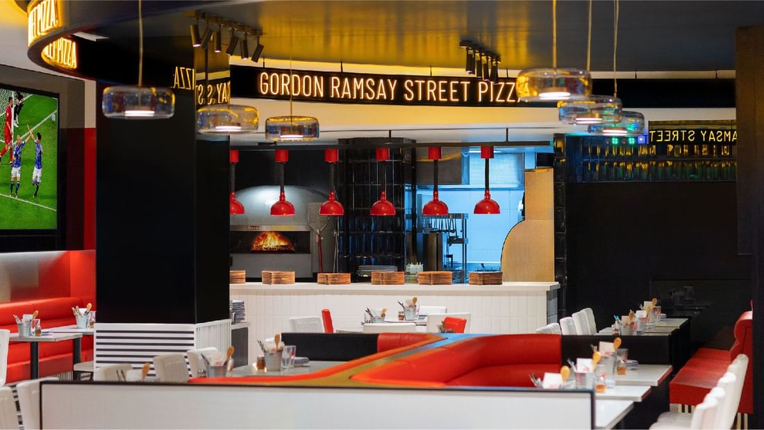 Interior of Gordon Ramsay Street Pizza, featuring red booths and a pizza oven, located at Sunway Lagoon Hotel