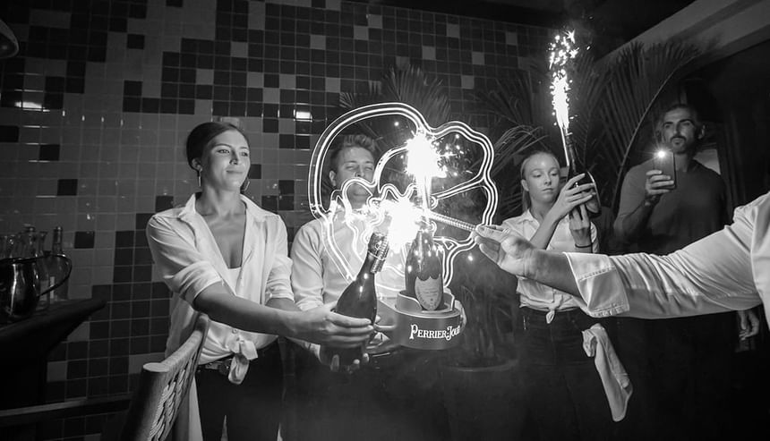 servers holding bottles of champagne with sparklers