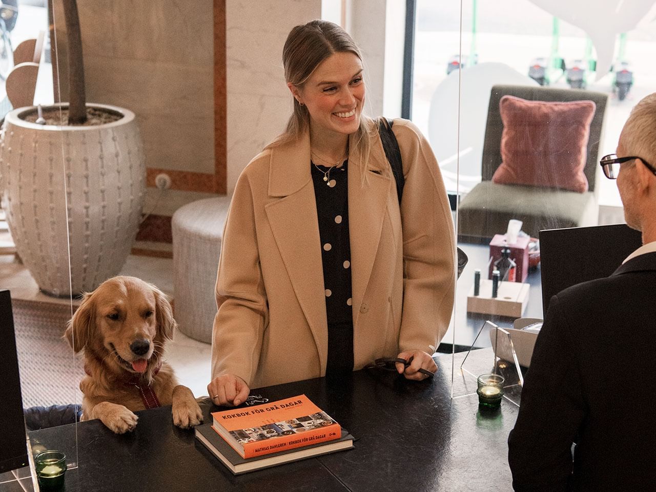 A women with her pet dog by the reception at The Sparrow Hotel 