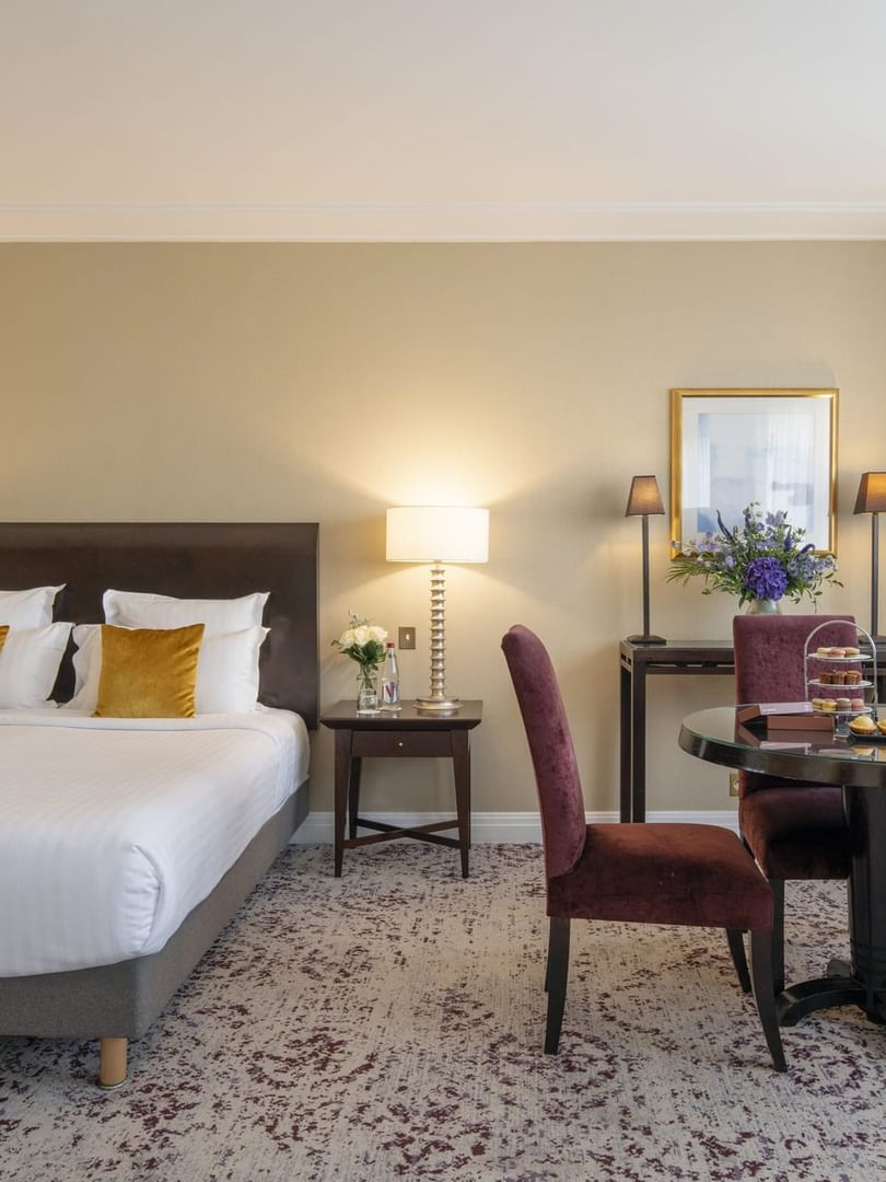 Une chambre Junior Suite à la décoration élégante et dotée d'un lit douillet au Warwick Champs-Élysées Paris.