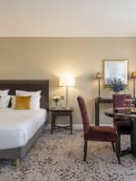 Une chambre Junior Suite à la décoration élégante et dotée d'un lit douillet au Warwick Champs-Élysées Paris.