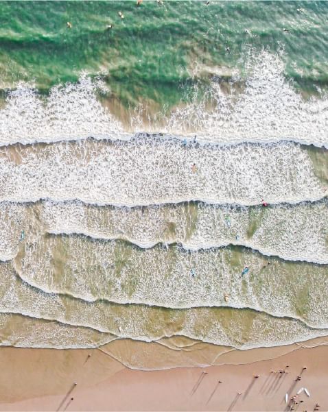 Aerial view of the sea waves from the ocean near Paradox Hotels