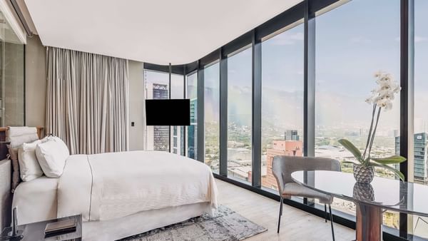 King bed and living area with city view of Luna Master Suite at FA Hotels & Resorts