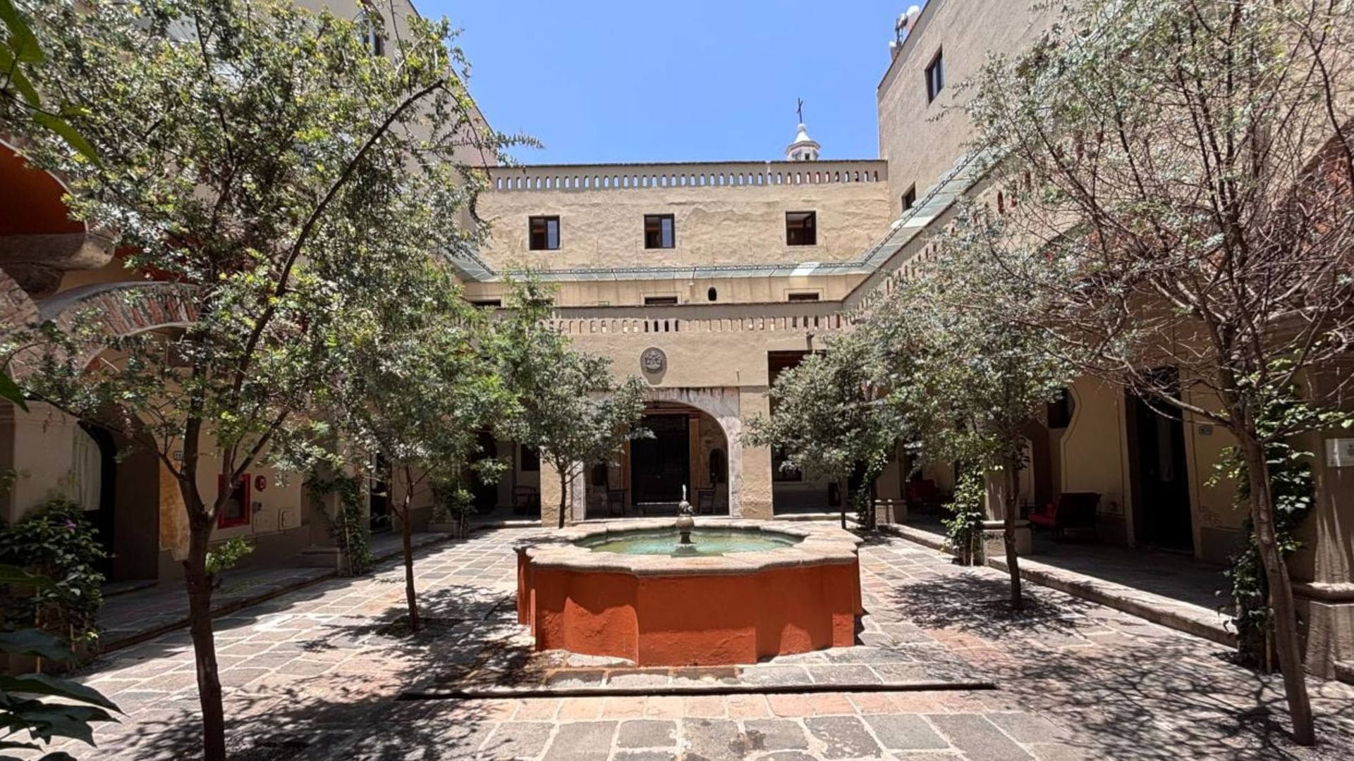 Elegant courtyard with central fountain and trees at Quinta Real Puebla in Heroica Puebla de Zaragoza.