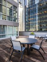 Outdoor wooden deck with dining setup and lounge chairs at Warwick Le Crystal Montreal