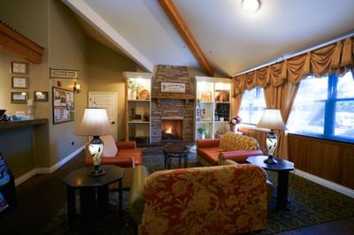 Cozy living room with fireplace, large window, and comfortable seating arrangement near the window.