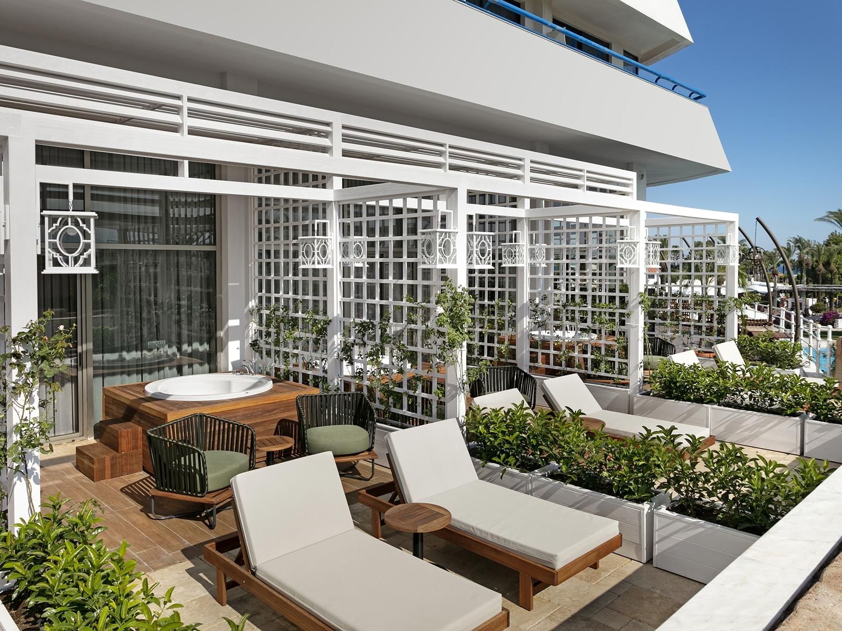 Sun loungers arranged by hot jacuzzi outdoors in Duplex Suite at Titanic Deluxe Lara