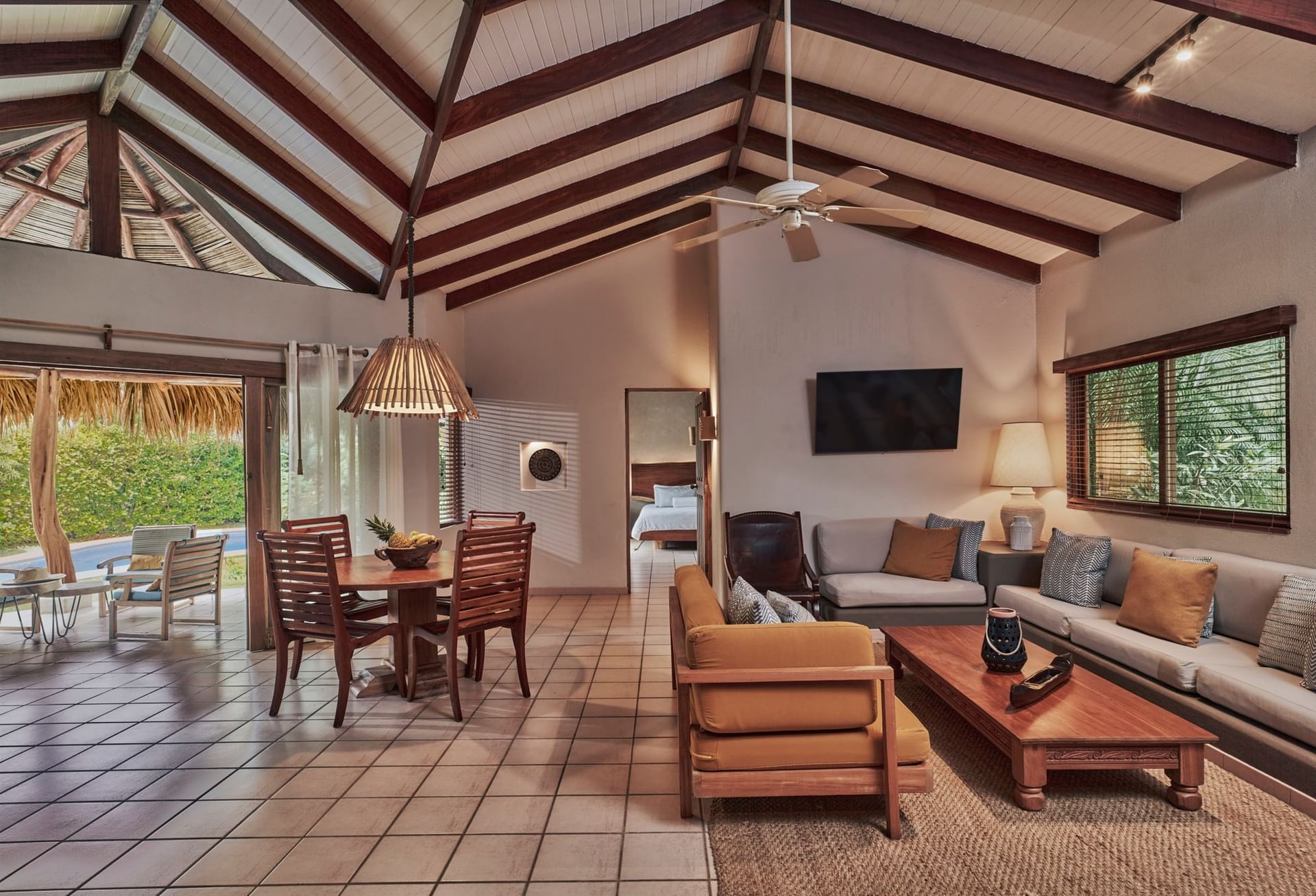 Living room with wooden furniture and ceiling fan at Cala Luna Boutique Hotel