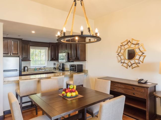 Charming dining area with chandelier full kitchen and wooden accents in the One Bedroom Villa at Hacienda Del Mar Los Cabos.
