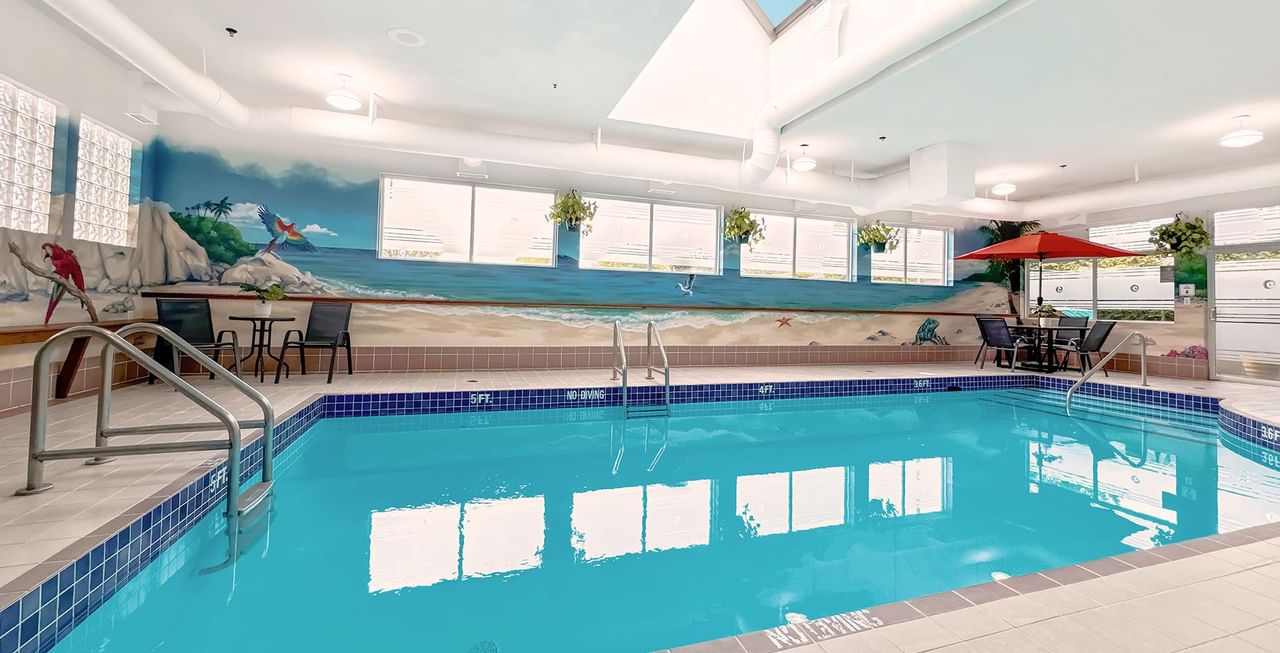 Hotel indoor pool with poolside table and umbrella