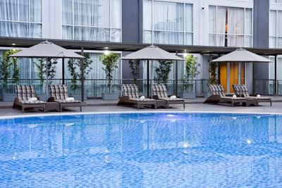 Sun loungers with canopies by the pool at Eastin Hotels