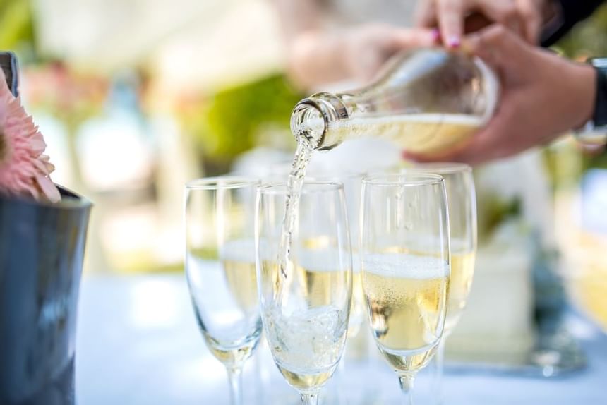 Chilled champagne being poured into elegant glass flutes during a toast at The Abidah Hotel by Accra