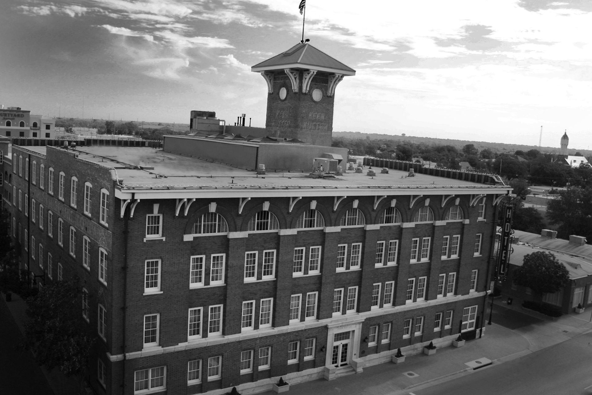 A large brick building with a clock tower in the background.