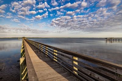 Aerial view of wooden boardwalk stretches over the calm waters near Grant Street Inn in Dunedin FL