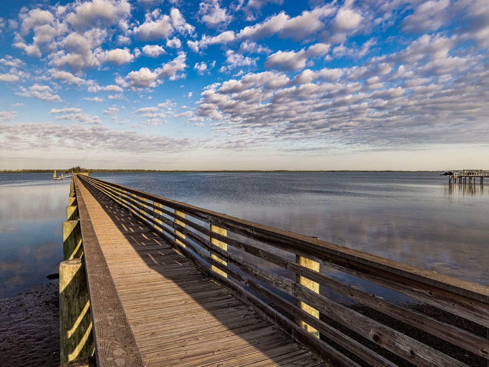 Aerial view of wooden boardwalk stretches over the calm waters near Grant Street Inn in Dunedin FL