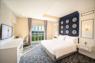 Double bed, TV & carpeted floor in Superior Room with Bal River view at Eastin Hotels