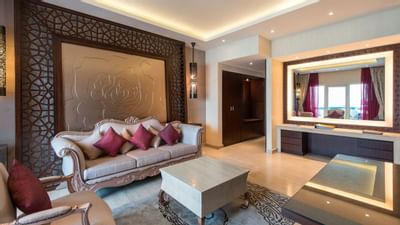 Living room with a mirror, sofas and red pillows at Ajman Hotel