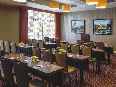 Olympic room at The Paramount Hotel Seattle with tables and chairs set up in rows facing a podium and artworks