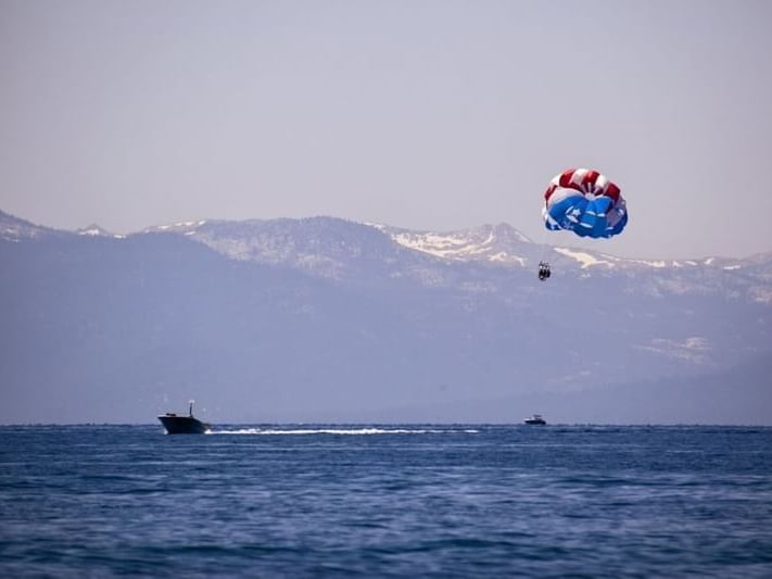 Parasailing experience with a mountain backdrop near Paradise Bay Resort