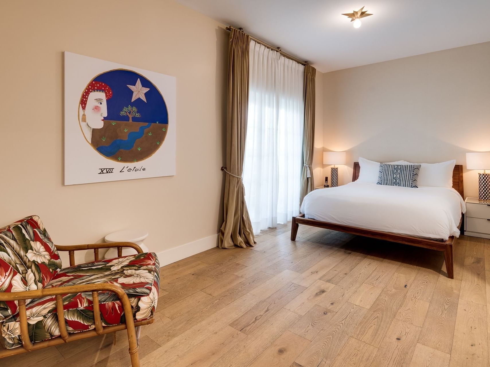 Lounger and nightstands by the bed in Queen Room with wooden floor at The Savoy Hotel & Beach Club