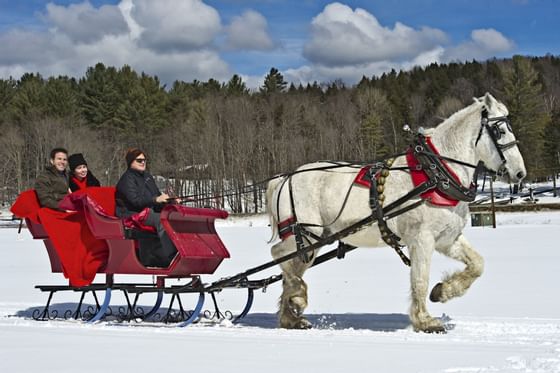 Three people on a sleigh ride near Topnotch Stowe Resort