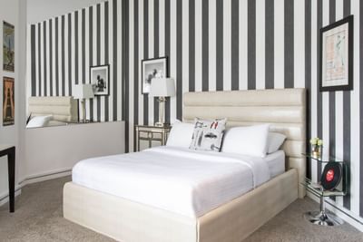 King bed with comfy pillows & lamp of Queen Premiere Rock & Roll at Retro Suites Hotel