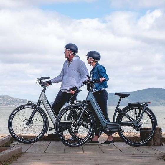 Mature couple riding bicycles while enjoying the sea view at Stein Eriksen Residences