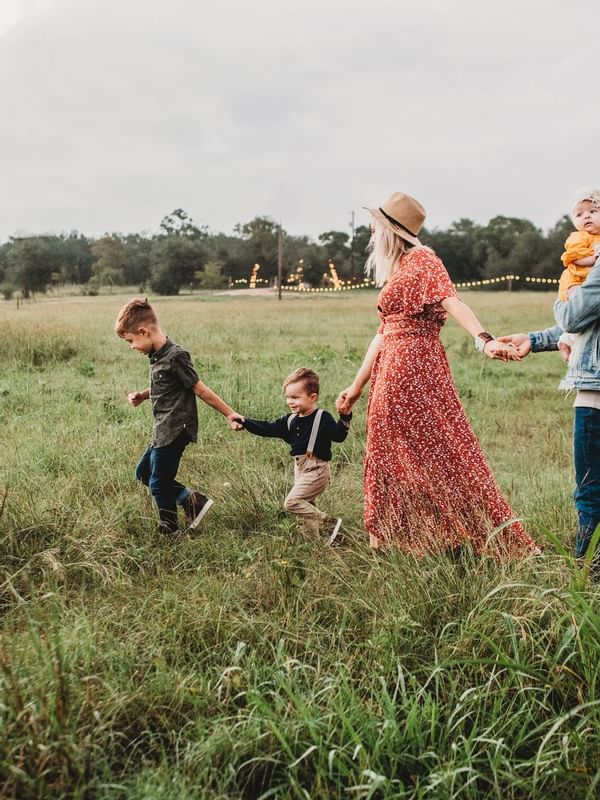 A family roaming around in a green meadow near Hotel Amiens Sud