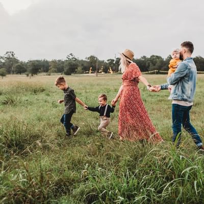 A family roaming around in a green meadow near Originals Hotels