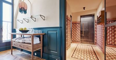 Spa entrance with a wooden shelf neatly arranged with towels and a bowl of fresh fruit at Hotel Motto Vienna