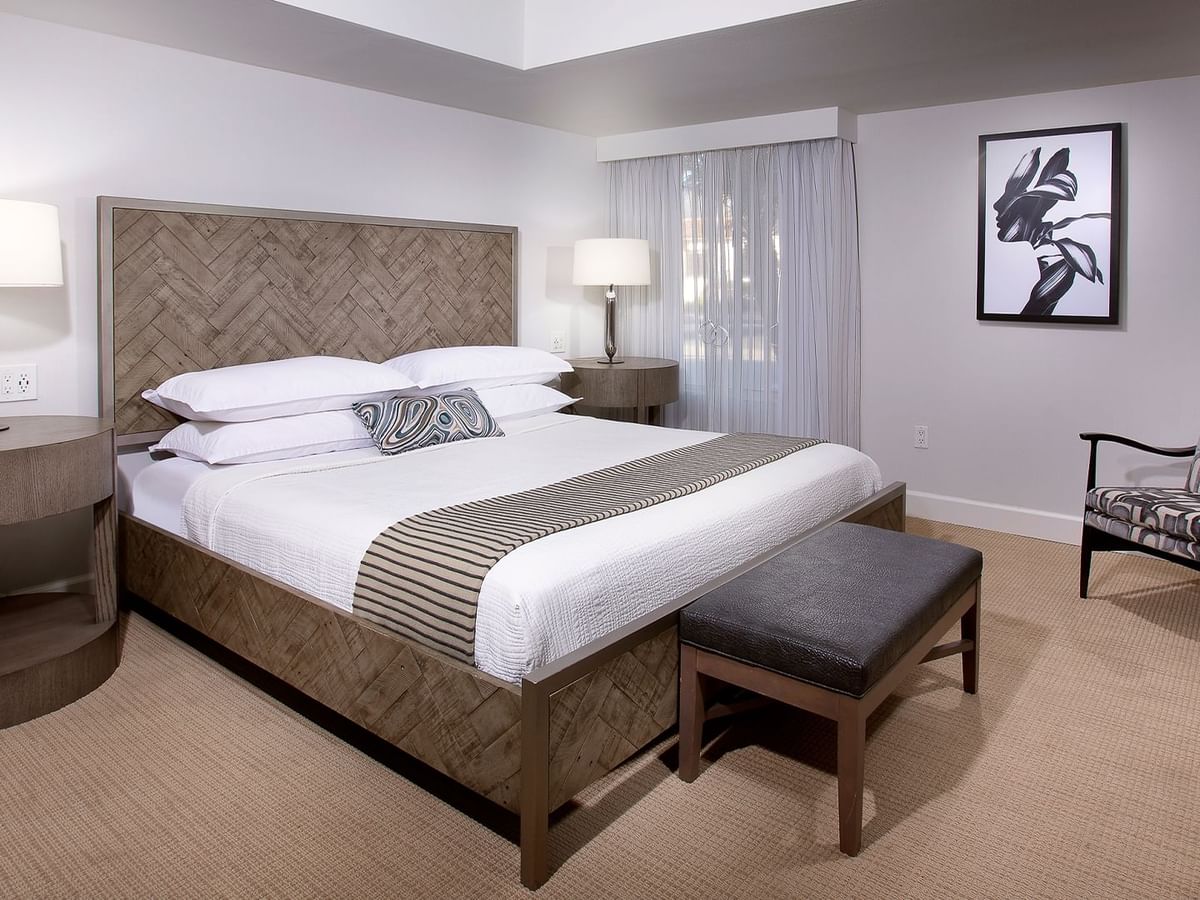 Hotel guestroom featuring a bed, a chair, and a nightstand