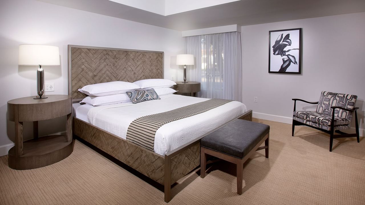 Hotel guestroom featuring a bed, a chair, and a nightstand
