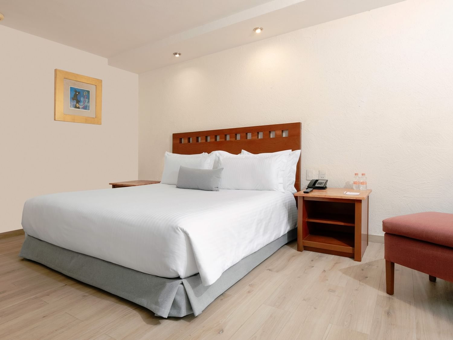 Habitación Camino Real Club King con cama grande, silla y mesa en Camino Real Guadalajara, Zapopan.