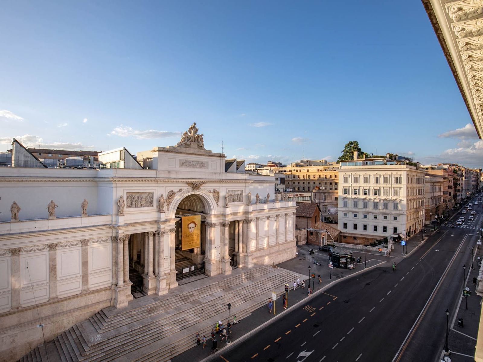 Palazzo delle Esposizioni surrounded by urban buildings and a wide street near The Glam Hotel