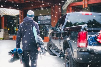 Man holding a snowboard and boots at Aava Whistler Hotel