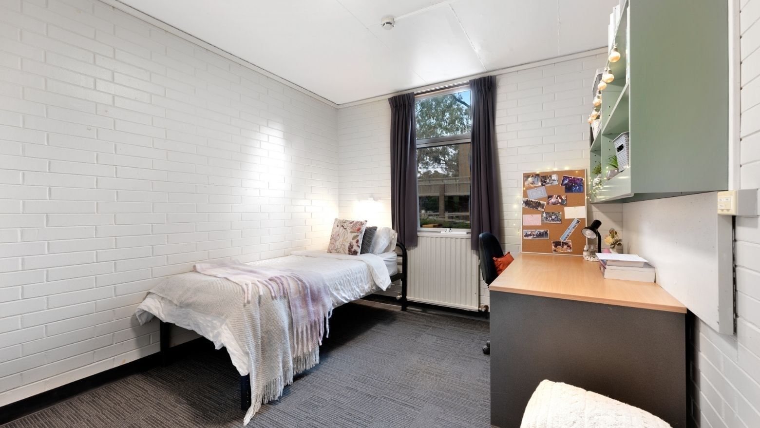 Small room with bed, desk, and window at La Trobe University - Glenn College.