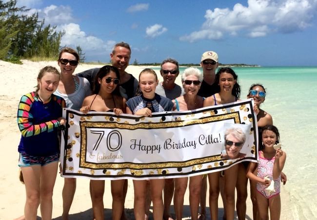 Tourists with 70th birthday banner, The Somerset on Grace Bay