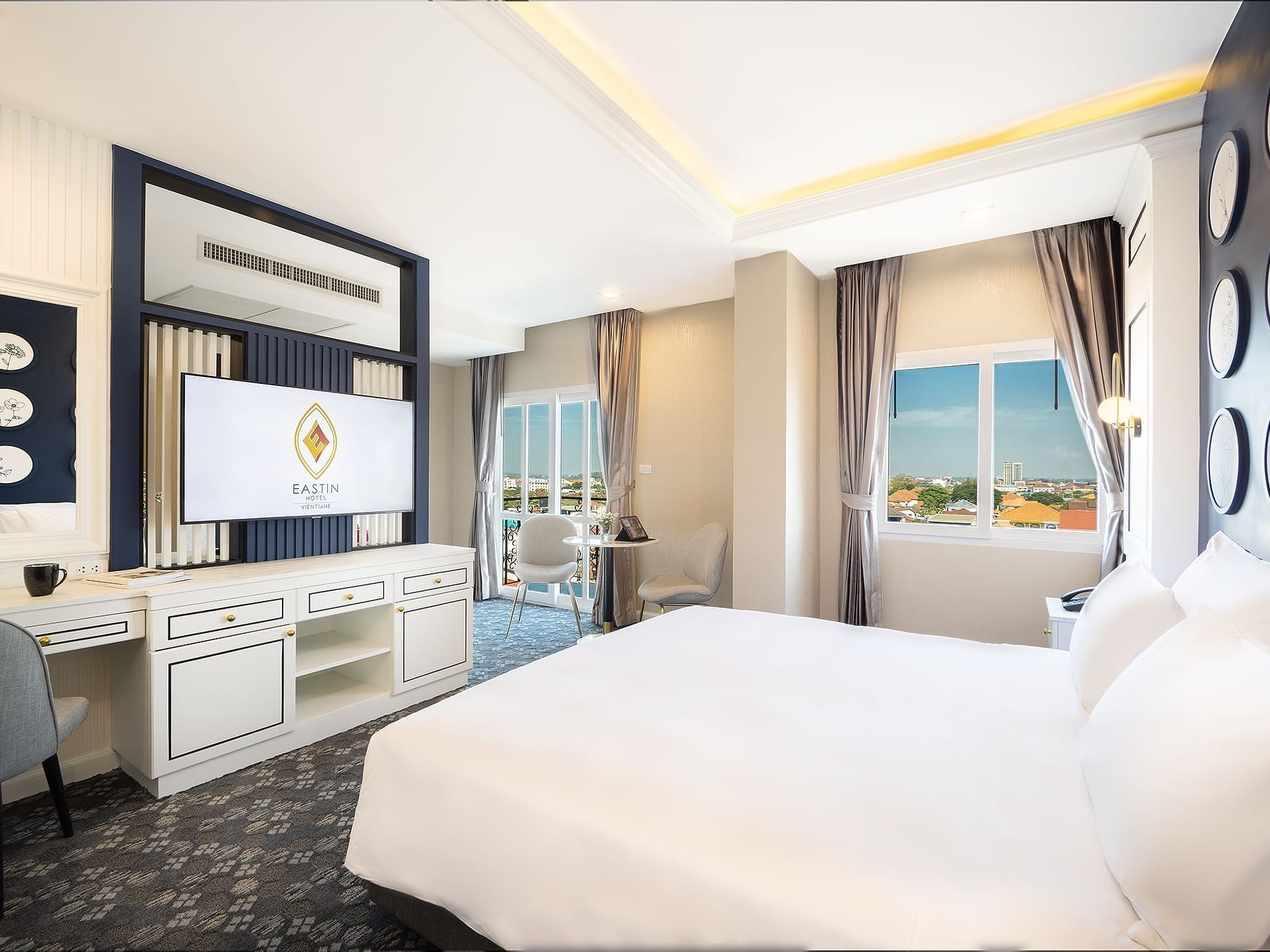 Bed with TV area in Deluxe Balcony City View, Eastin Hotels