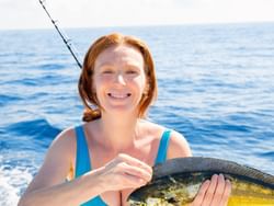 Woman holding a Mahi Mahi fish in the Florida Keys near Bayside Inn Key Largo