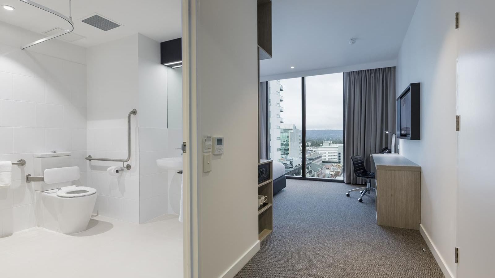 Special Access Room featuring a spacious bathroom and workspace with a city view at Ibis Adelaide
