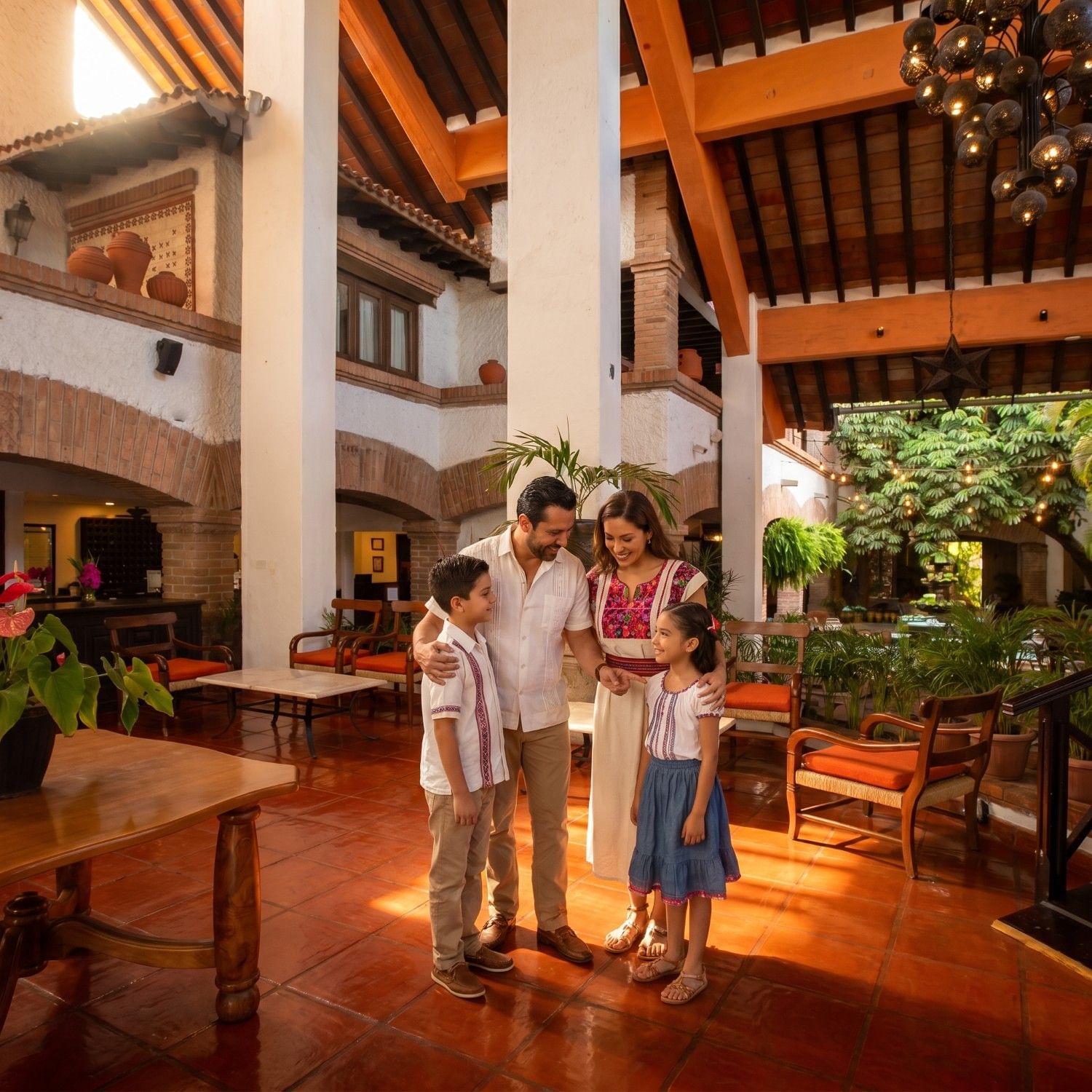 Family reconnecting in the traditional hacienda-style lobby of Hacienda Buenaventura Hotel & Mexican Charm in Puerto Vallarta