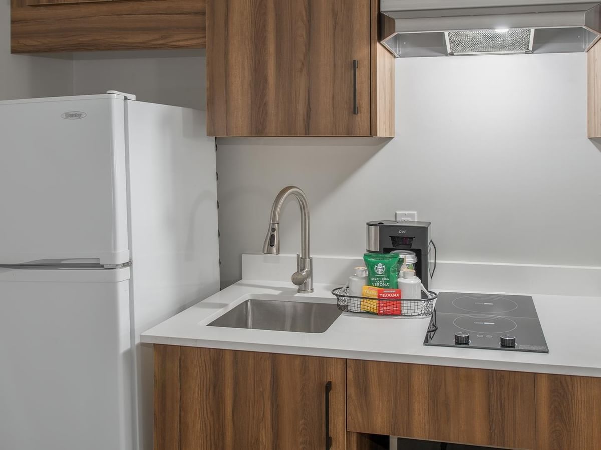 Kitchenette with refrigerator, sink, and coffee maker.